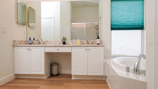 bathroom with wood-type flooring, plus walk in shower, and vanity