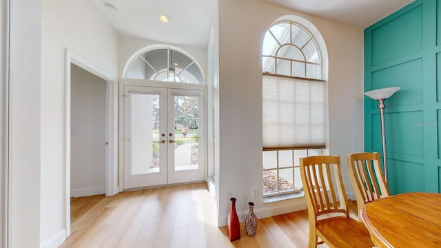 entrance foyer with french doors and light hardwood / wood-style flooring