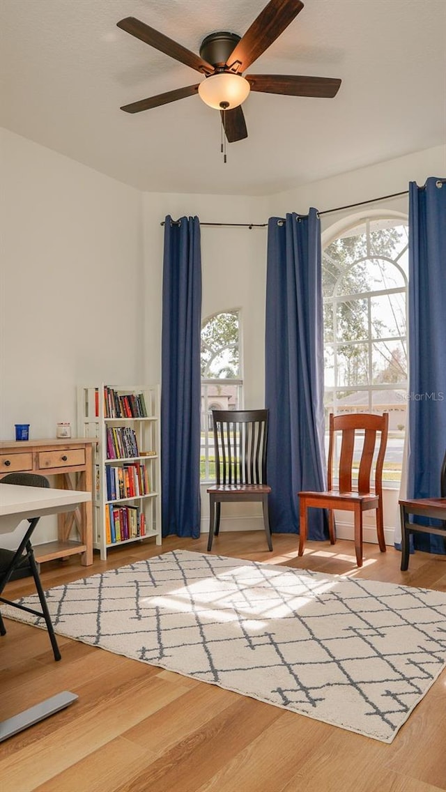 sitting room featuring ceiling fan, wood-type flooring, and plenty of natural light