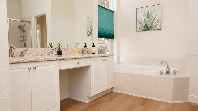 bathroom with vanity, shower with separate bathtub, and hardwood / wood-style floors