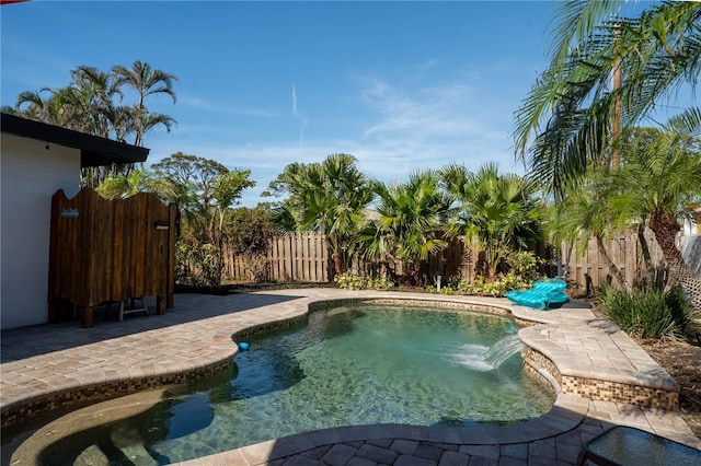 view of swimming pool with pool water feature and a patio area