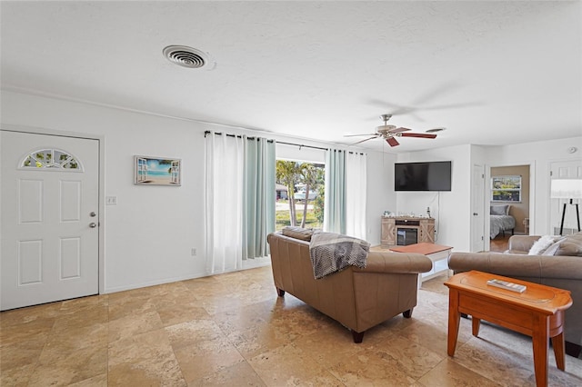 1309 Nokomis Ave S, Venice, FL 34285 - living room with a ceiling fan and light stone finish floors