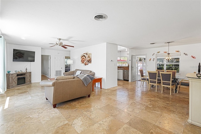 1309 Nokomis Ave S, Venice, FL 34285 - living room featuring a fireplace, stone tile flooring, and ceiling fan