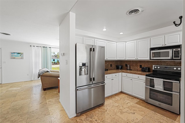 1309 Nokomis Ave S, Venice, FL 34285 - kitchen featuring stainless steel appliances, white cabinetry, backsplash, stone tile floors, and dark countertops