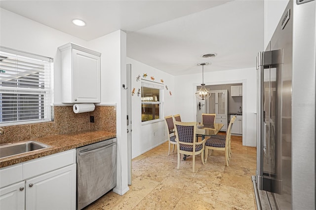 1309 Nokomis Ave S, Venice, FL 34285 - kitchen featuring stainless steel appliances, white cabinets, dark countertops, a chandelier, and backsplash