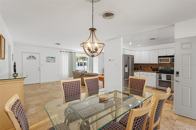 1309 Nokomis Ave S, Venice, FL 34285 - dining room featuring a chandelier and light stone finish floors