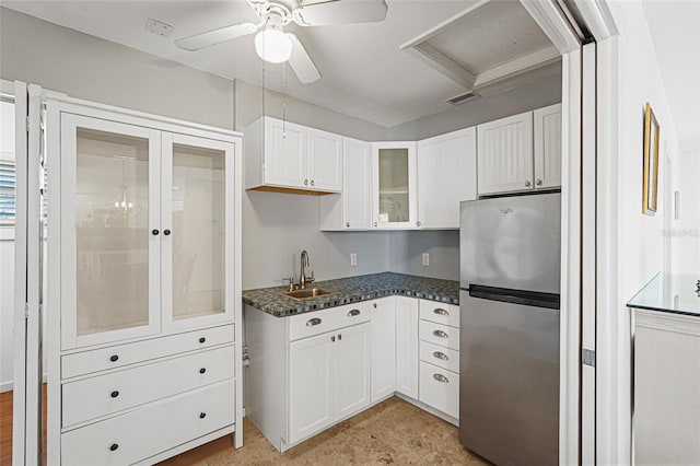 1309 Nokomis Ave S, Venice, FL 34285 - kitchen featuring freestanding refrigerator, white cabinets, glass insert cabinets, a ceiling fan, and dark countertops