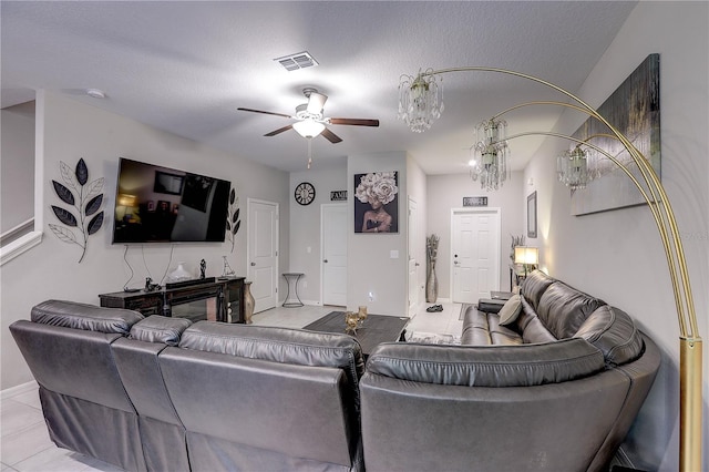 living room with light tile patterned floors, a textured ceiling, and ceiling fan