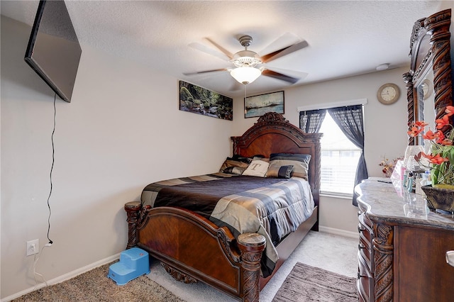 carpeted bedroom with ceiling fan and a textured ceiling