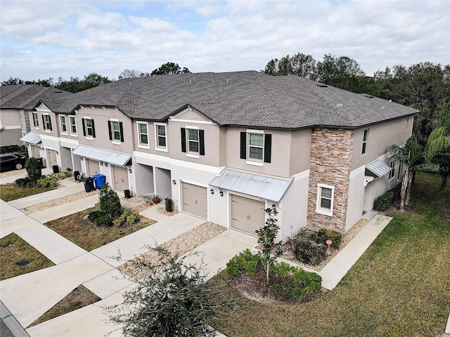 townhome / multi-family property with a garage and a front lawn