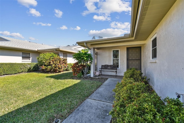 view of exterior entry with a yard