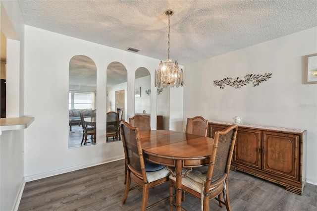 dining space featuring dark wood-type flooring and a textured ceiling