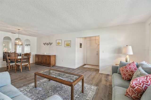 living room featuring an inviting chandelier, hardwood / wood-style floors, and a textured ceiling