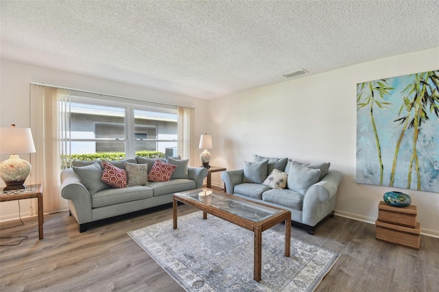 living room with wood-type flooring and a textured ceiling