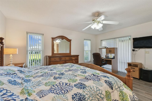 bedroom featuring a textured ceiling, ceiling fan, and light hardwood / wood-style flooring