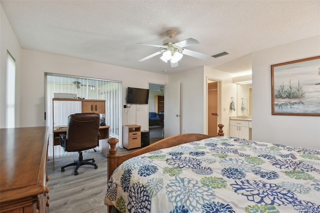 bedroom featuring ceiling fan, a textured ceiling, and light wood-type flooring