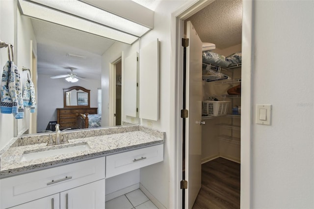 bathroom with vanity, a textured ceiling, and ceiling fan