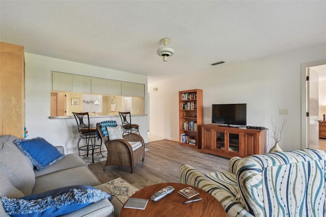 living room featuring light hardwood / wood-style flooring and a textured ceiling