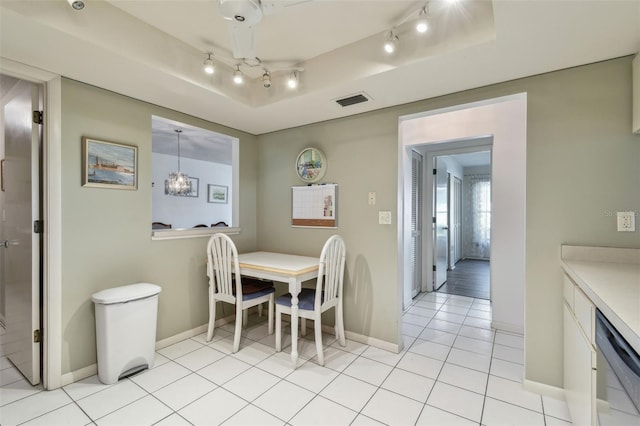 dining room with light tile patterned floors and a tray ceiling