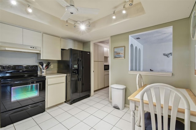 kitchen featuring ceiling fan, black appliances, white cabinets, light tile patterned flooring, and a raised ceiling