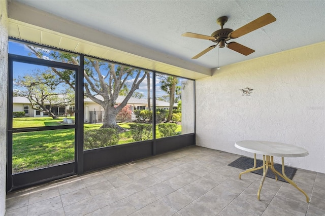 unfurnished sunroom featuring ceiling fan