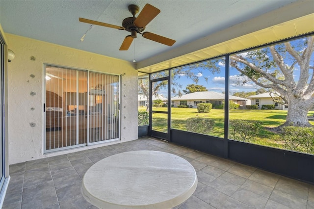 unfurnished sunroom with ceiling fan