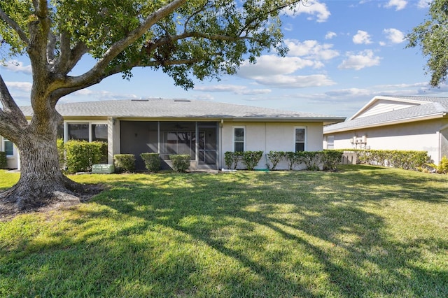 rear view of property with a lawn and a sunroom