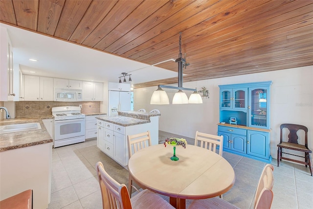 dining area featuring sink, light tile patterned floors, and wooden ceiling