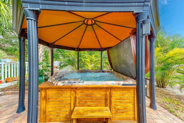 view of patio / terrace featuring a hot tub and a gazebo