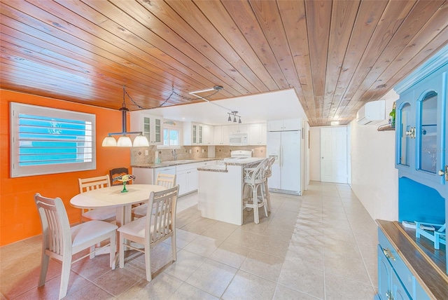 tiled dining space featuring sink, a wall mounted AC, and wooden ceiling