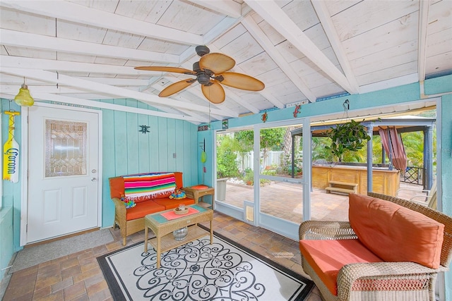 sunroom with vaulted ceiling with beams, wood ceiling, and ceiling fan