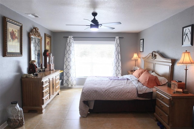 tiled bedroom featuring ceiling fan and a textured ceiling