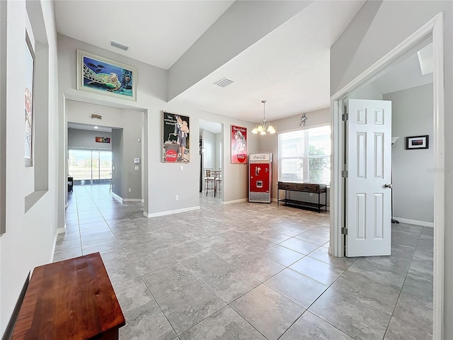 interior space with light tile patterned floors and a notable chandelier