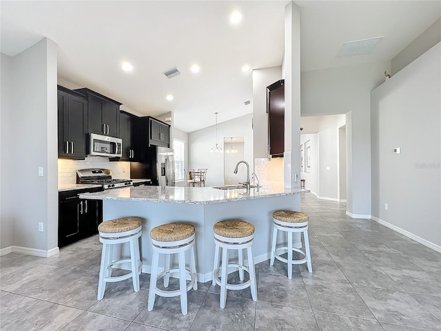 kitchen featuring appliances with stainless steel finishes, sink, lofted ceiling, and backsplash