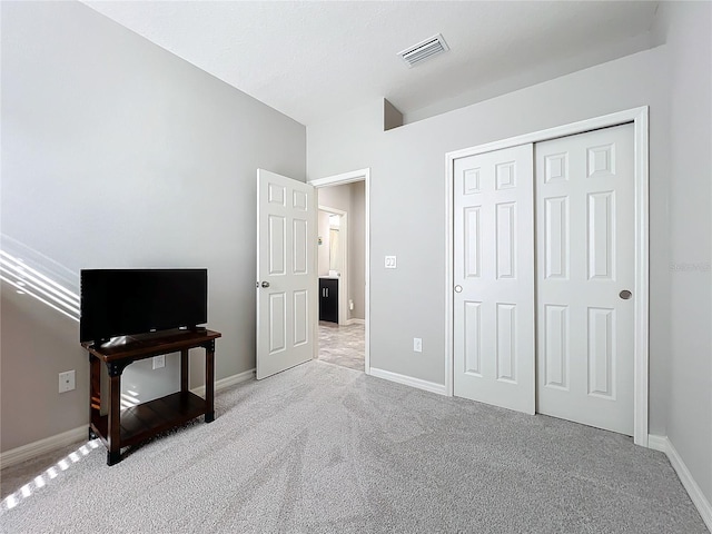 bedroom with light carpet and a closet