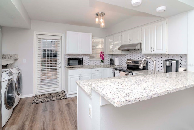 kitchen featuring white cabinets, stainless steel appliances, kitchen peninsula, and washing machine and dryer