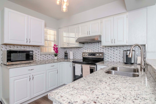 kitchen featuring sink, white cabinets, decorative backsplash, stainless steel appliances, and light stone countertops