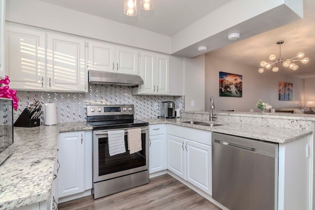 kitchen featuring stainless steel appliances, white cabinetry, sink, and pendant lighting