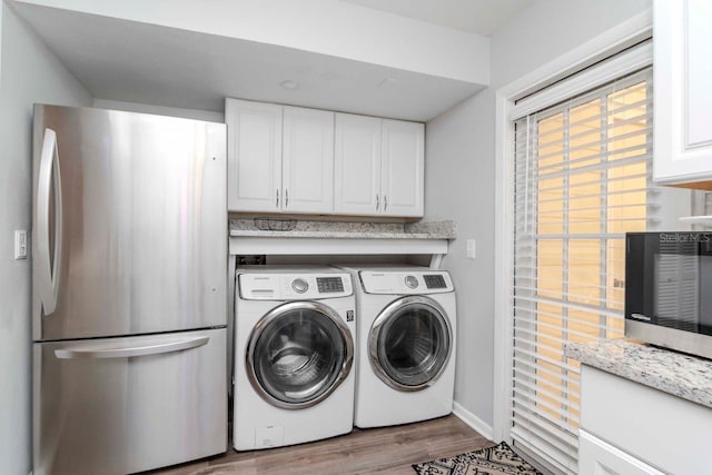 laundry area with light hardwood / wood-style floors and independent washer and dryer