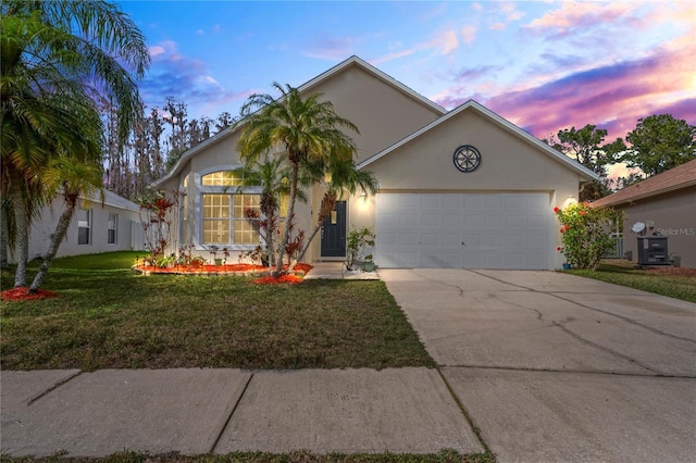 view of front of property with a garage and a lawn