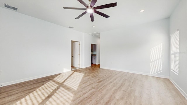 empty room with ceiling fan and light hardwood / wood-style floors