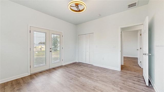 spare room with light hardwood / wood-style flooring and french doors