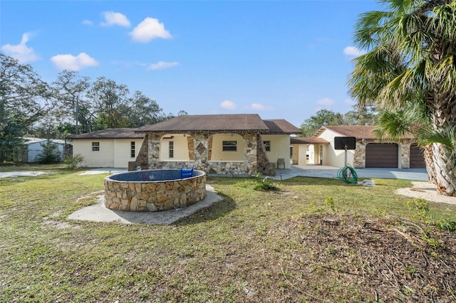 rear view of house featuring a garage and a lawn