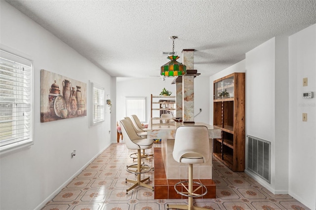 dining space featuring a fireplace and a textured ceiling