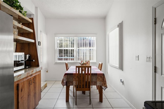 tiled dining area featuring a textured ceiling