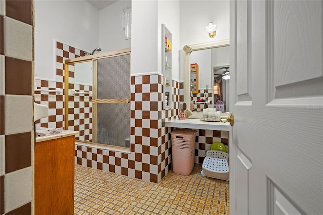 bathroom with walk in shower, ceiling fan, tile patterned flooring, and tile walls