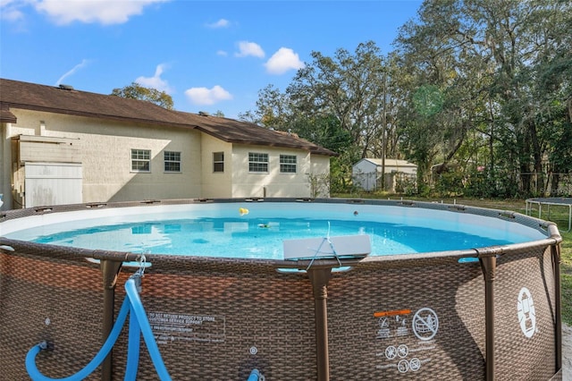 view of swimming pool with a trampoline