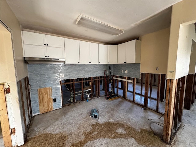 interior space featuring concrete floors and white cabinets