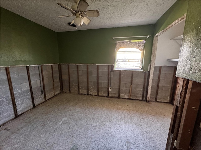 empty room featuring ceiling fan and a textured ceiling