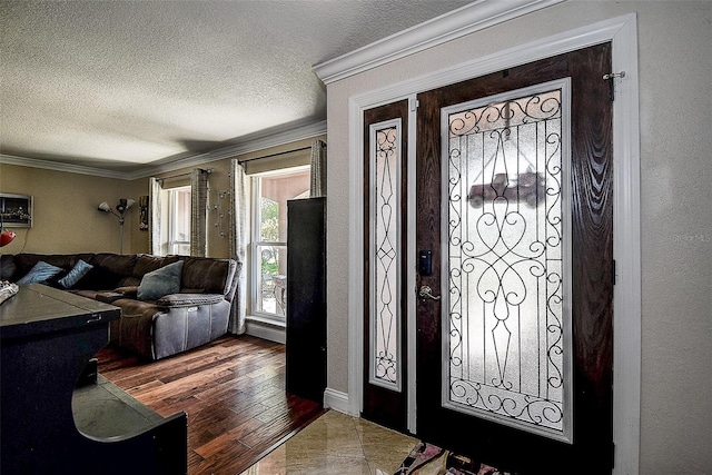 entrance foyer featuring hardwood / wood-style flooring, ornamental molding, and a textured ceiling